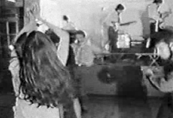 Image extraite de la vidéo London 66-67. On peut voir les gens qui dansent au premier plan et Pink Floyd, au fond sur la scène.